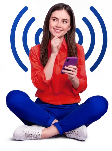 A girl sitting cross legged with her hand on her chin and using mobile phone